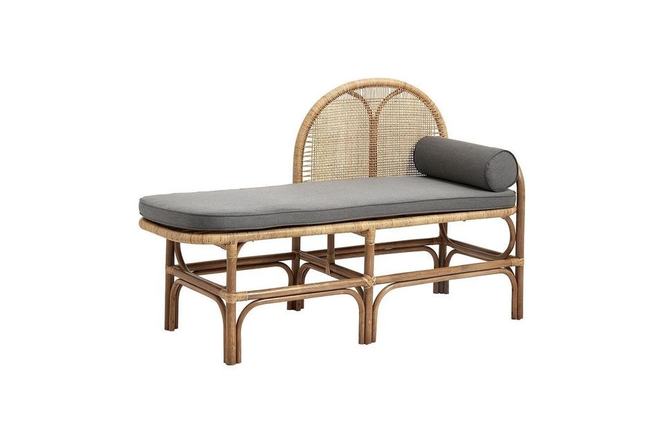 The originality of its silhouette lies in the fact that the rounded backrest in woven rattan covers