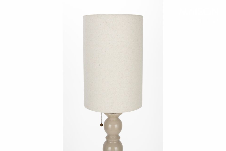 The soft glow diffused by its linen shade envelops the space in soothing warmth
