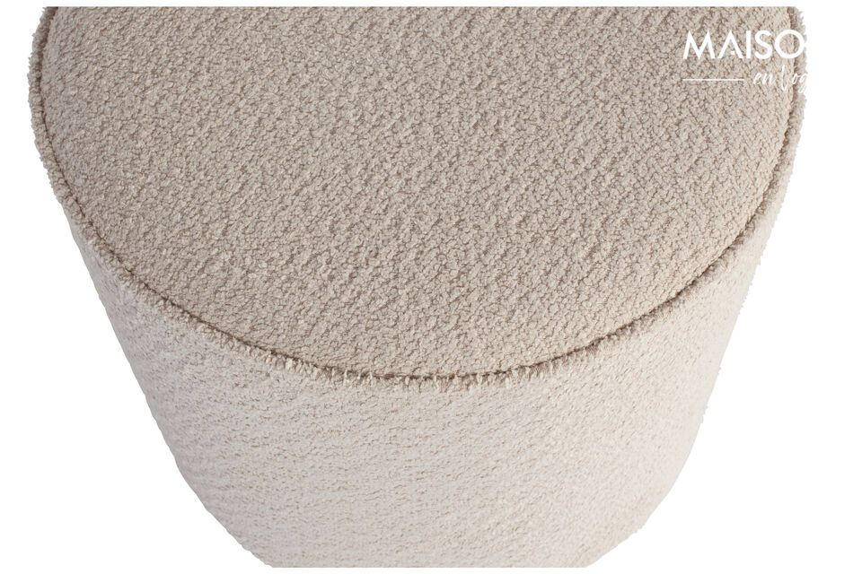 The cream colored sheepskin effect round pouffe is from the collection of the Dutch interior design