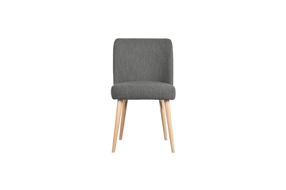 It is upholstered in a trendy looped fabric in a sober grey tone that allows it to easily blend