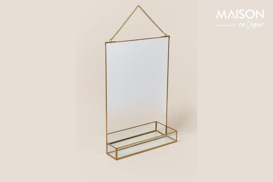 A mirror and its shelf highlighted by a gold finish
