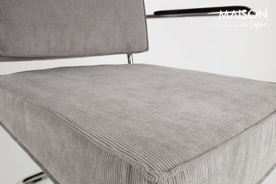 Its seat and backrest, stretched in light grey corduroy, are generously upholstered