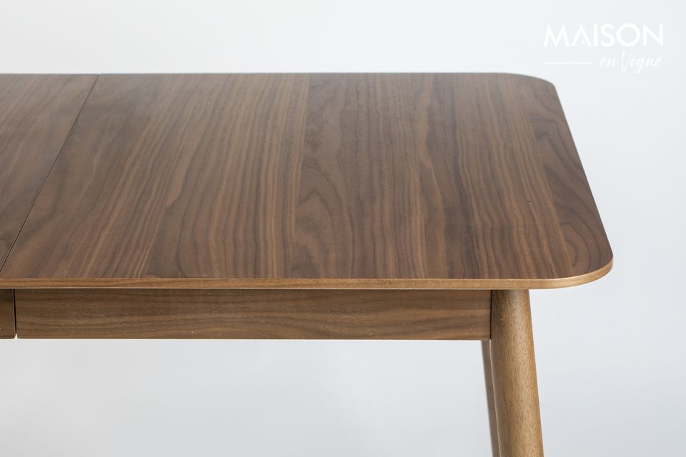 An extendable dining table in walnut veneer