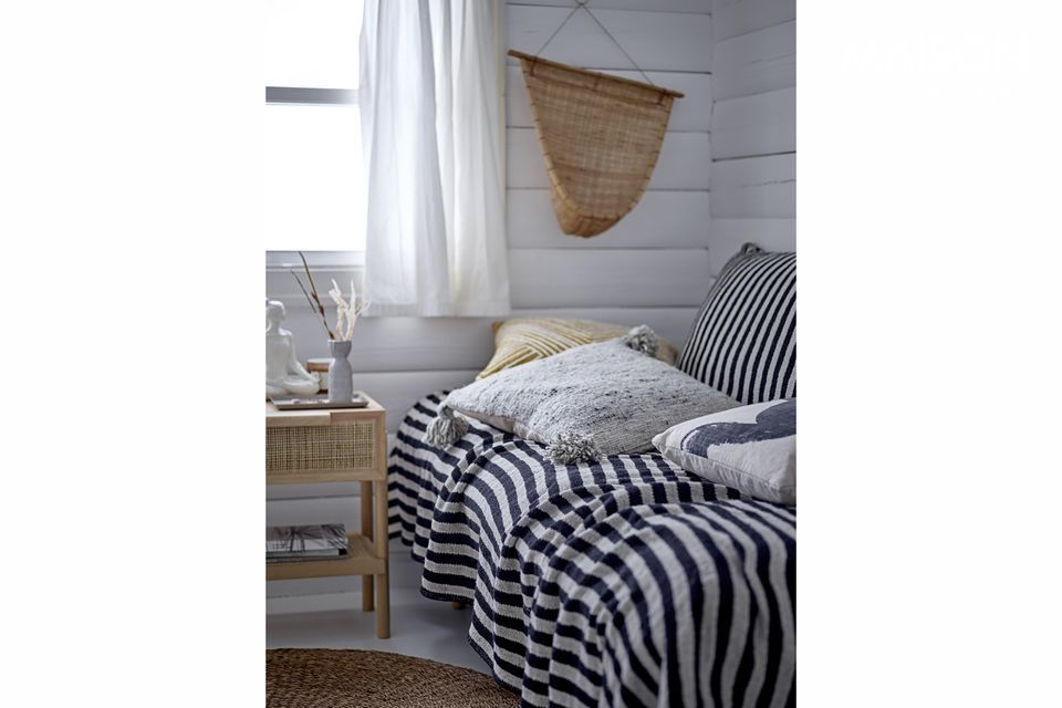 A simple white cushion woven in cotton with a printed pattern that reminds us of brushstrokes of